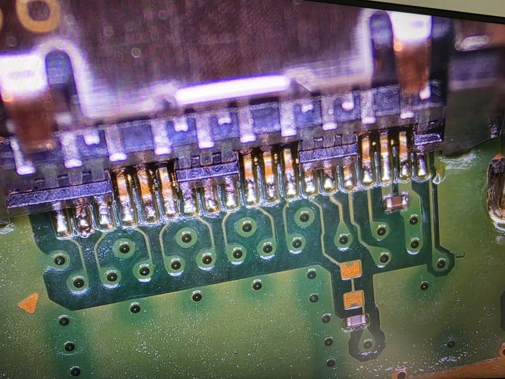PS5 HDMI port pins and solder pads viewed under a microscope