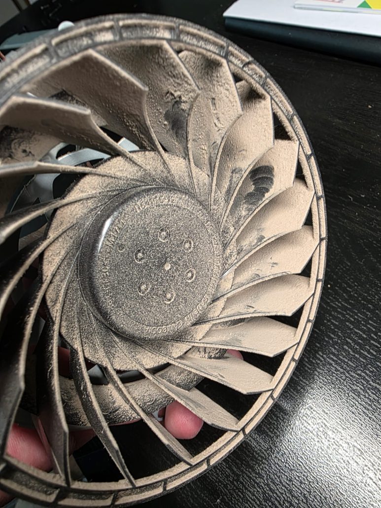 PS5 fan with dust built up on the blades restricting airflow