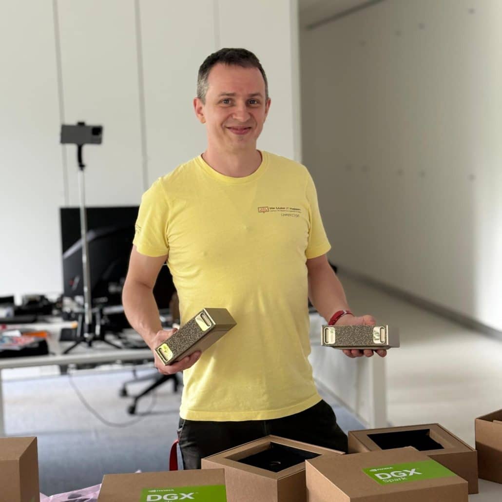 Jacob, founder of We Make IT Happen, holding two NVIDIA DGX Spark units in the workshop