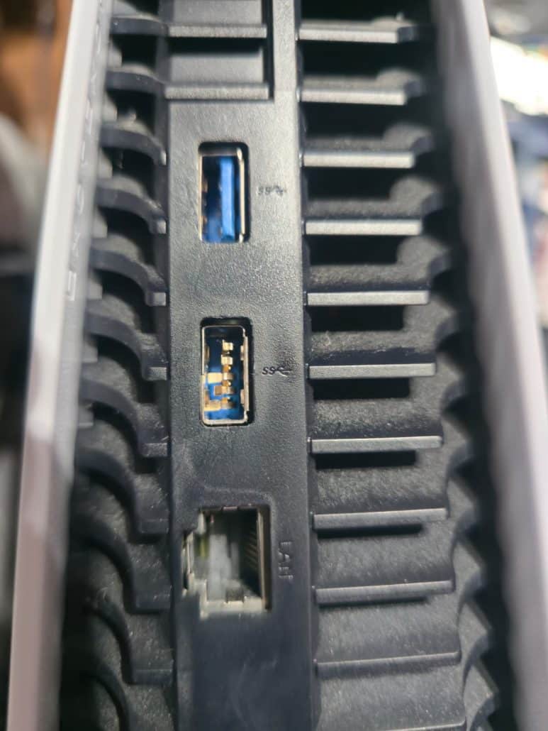 PS5 rear USB port with damaged pins next to the LAN port