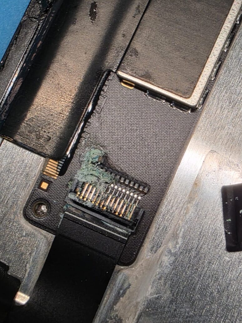 Corroded flex cable connector inside a MacBook after a liquid spill