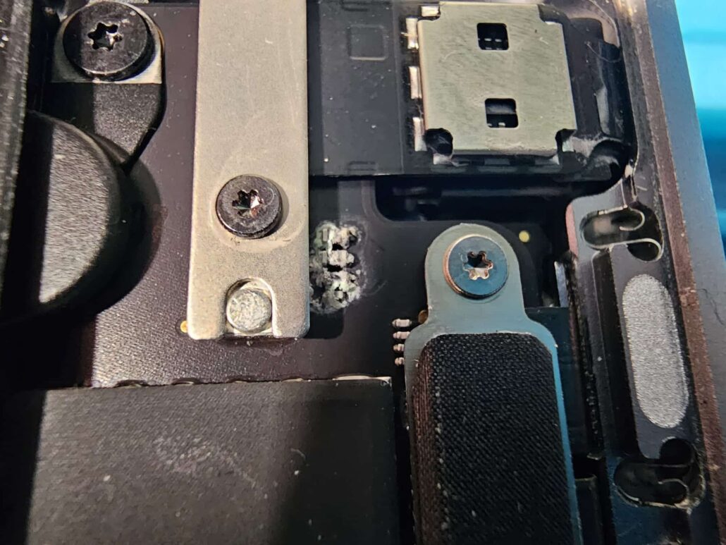 Corrosion spreading under the hinge bracket of a MacBook Air after liquid got inside