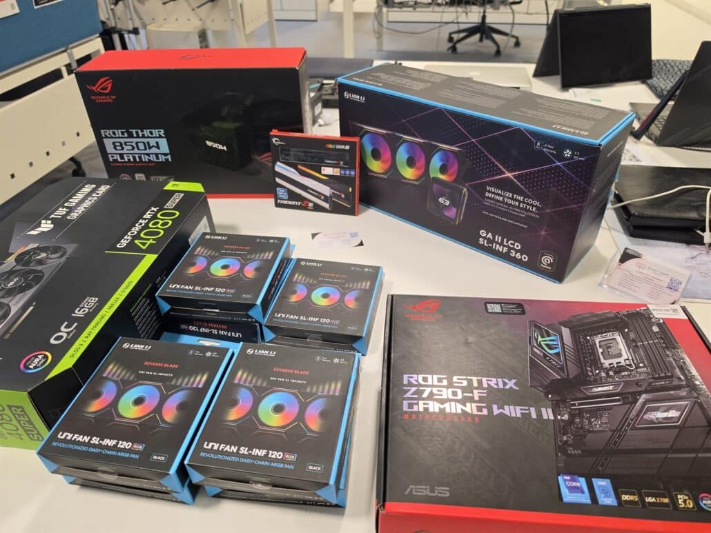 Boxed parts for a custom PC build on our workshop bench: ASUS ROG Strix Z790-F motherboard, TUF GeForce RTX 4080 SUPER, ROG Thor 850 W power supply, Lian Li Galahad II LCD 360 cooler, G.Skill Trident Z5 RGB memory and Lian Li Uni Fan boxes