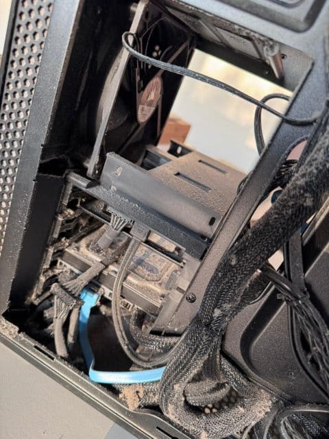Dusty cables and a fan inside a desktop PC case