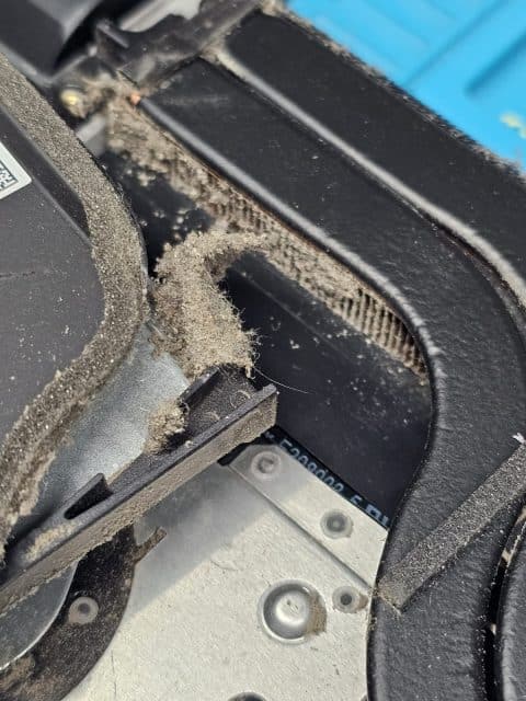 Dust and lint trapped between laptop heatsink fins and the fan housing