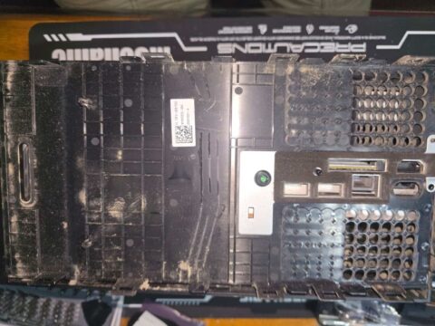 Dusty inside of an Xbox case panel with vents and port cut-outs