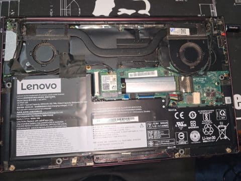 Opened Lenovo laptop showing two cooling fans and heat pipes