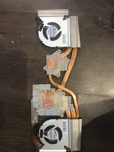 Gaming laptop heatsink with its copper heat pipes and both fans removed for cleaning