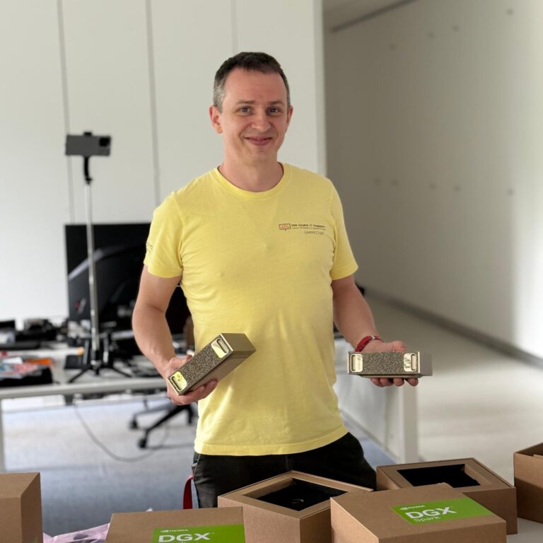 Jacob, founder of We Make IT Happen, holding two NVIDIA DGX Spark units in the workshop
