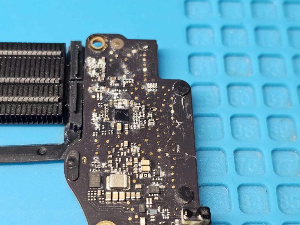 Dried liquid residue and corrosion on a MacBook Air I/O board next to the heatsink