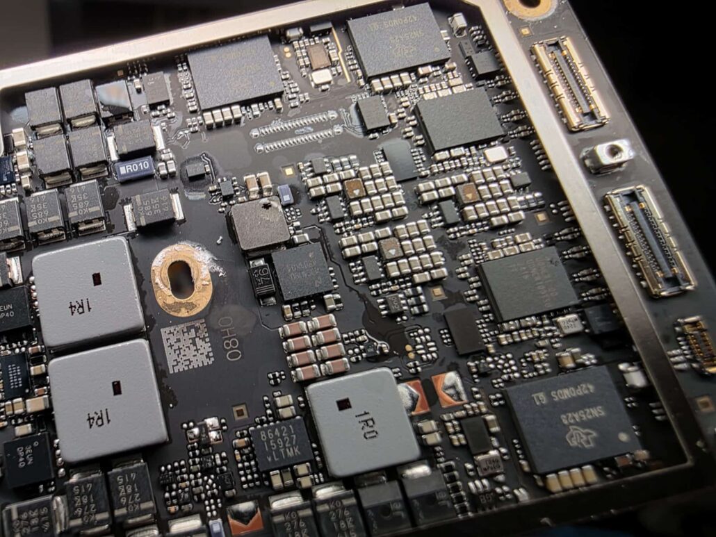 Close-up of a MacBook logic board during inspection after a liquid spill