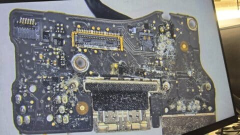 MacBook Pro board covered in corrosion after a drink was spilled on the keyboard and the laptop kept being used