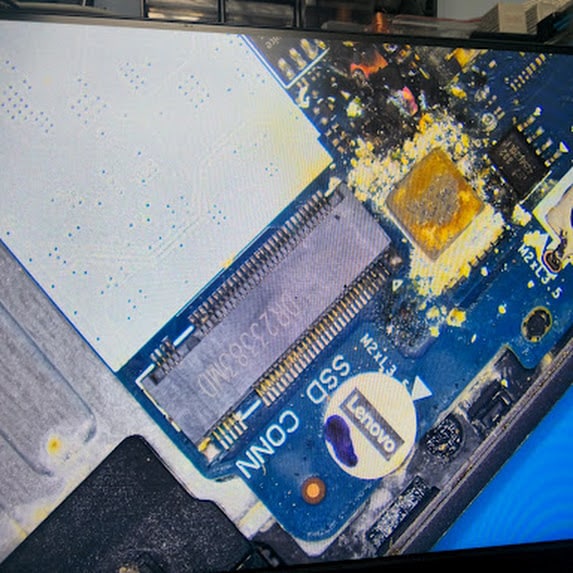 Liquid residue around the M.2 SSD connector on a laptop motherboard