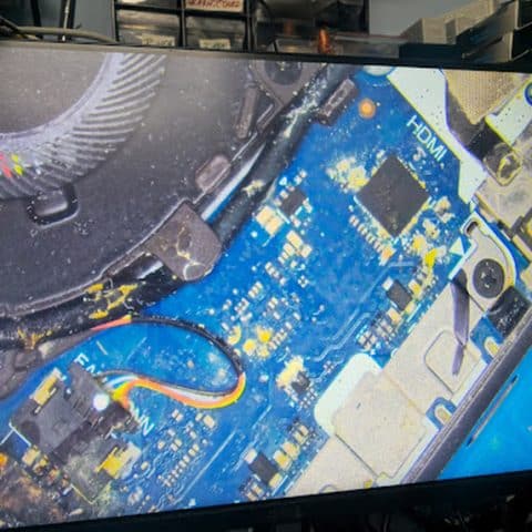 Liquid residue near the fan area of a laptop motherboard
