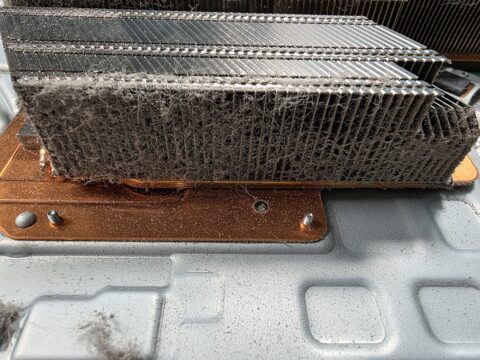 PS5 heatsink with copper base and dust built up between the fins